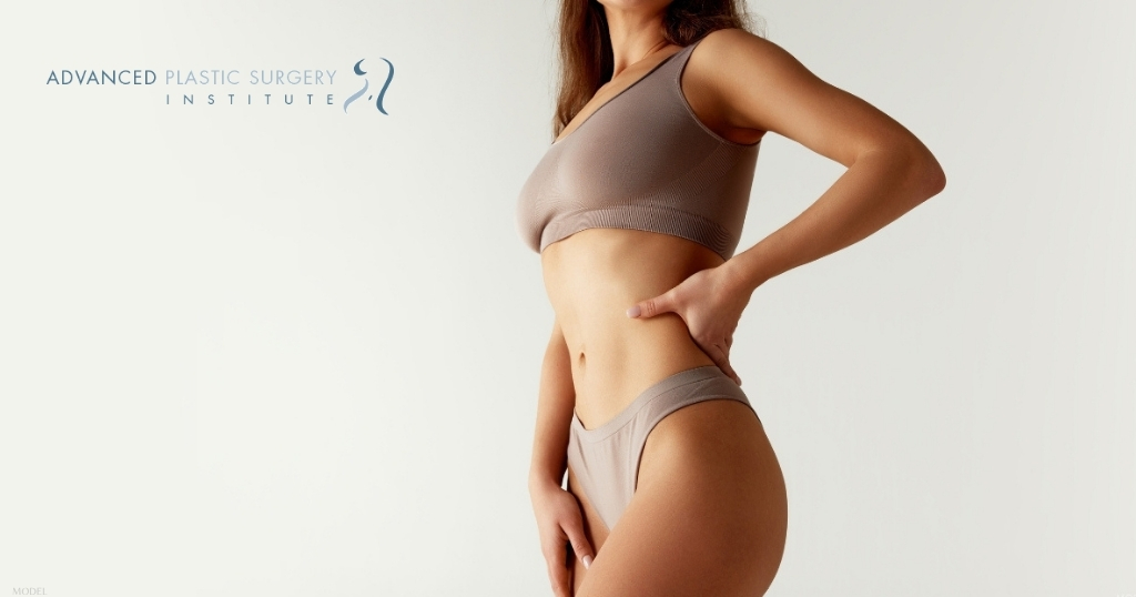 A woman standing in front of a white background (model)