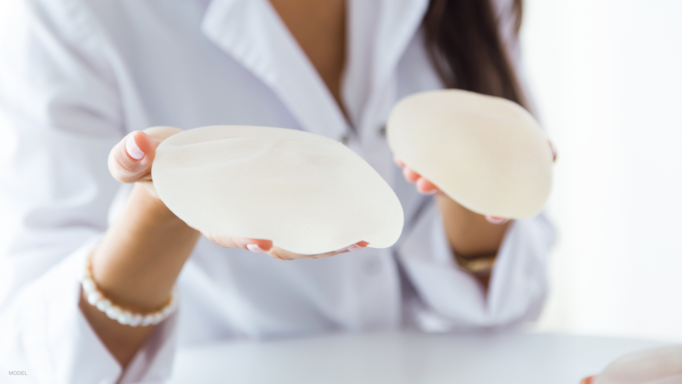 Woman holding breast implants