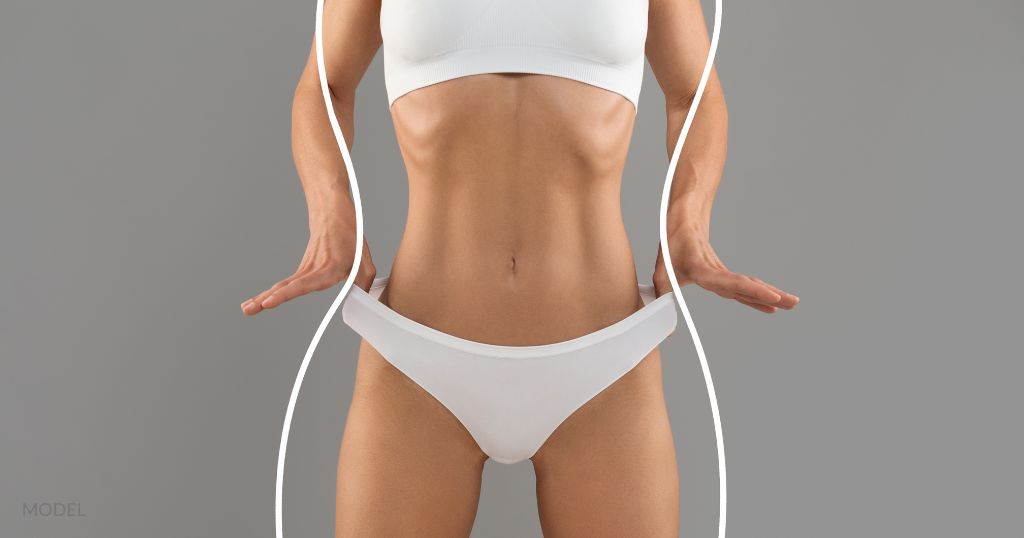 Very fit woman in white underwear, stretches her bottoms to demonstrate weight loss. (Model)