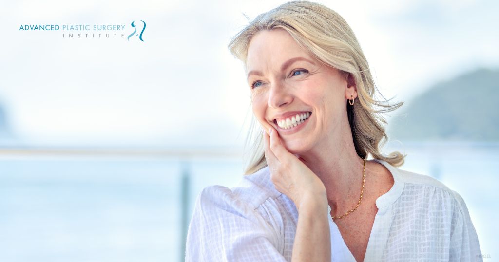 Woman smiling with hands on her face (MODEL)