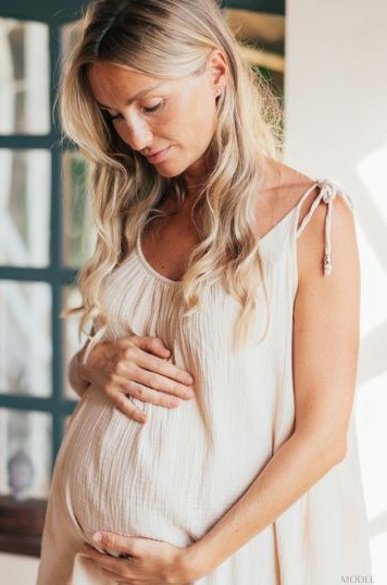 Pregnant woman looking down (model)
