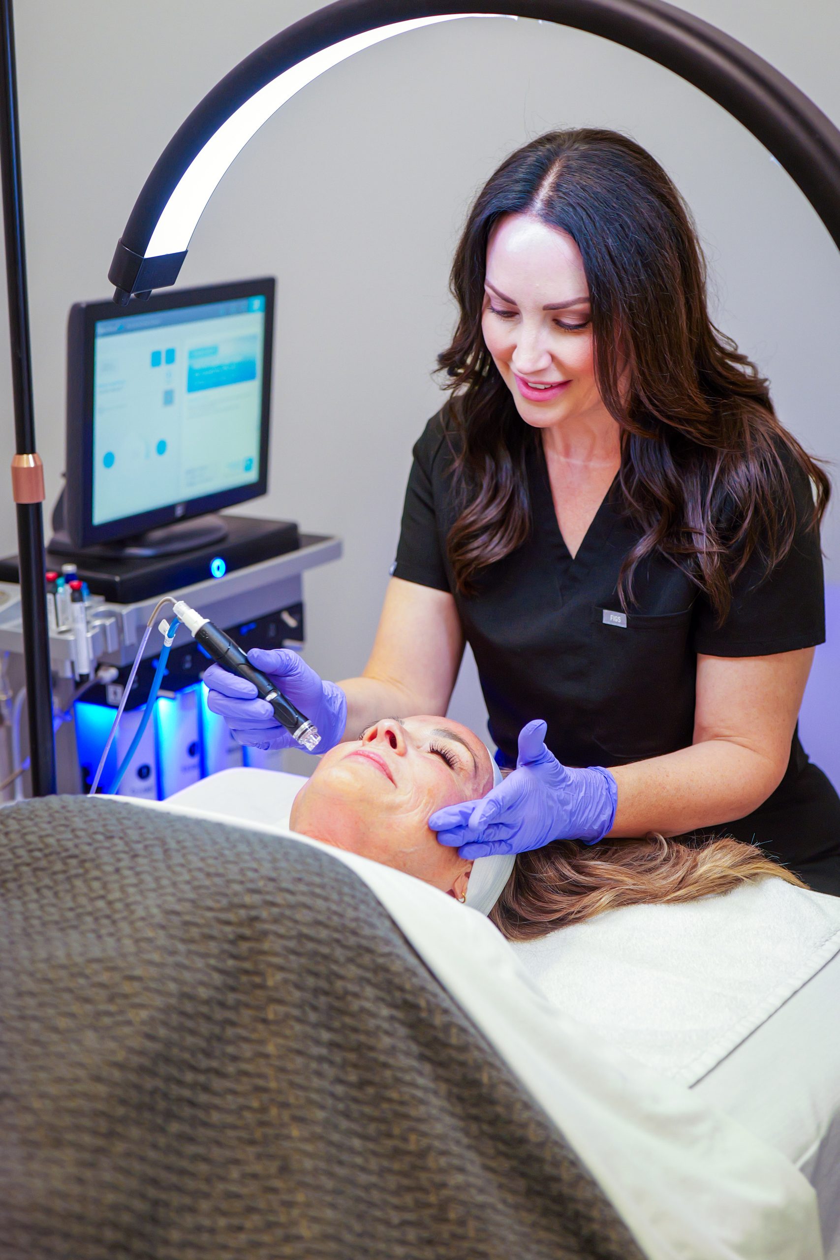 Advanced Plastic Surgery Institute staff performing microneedling treatment on a patient