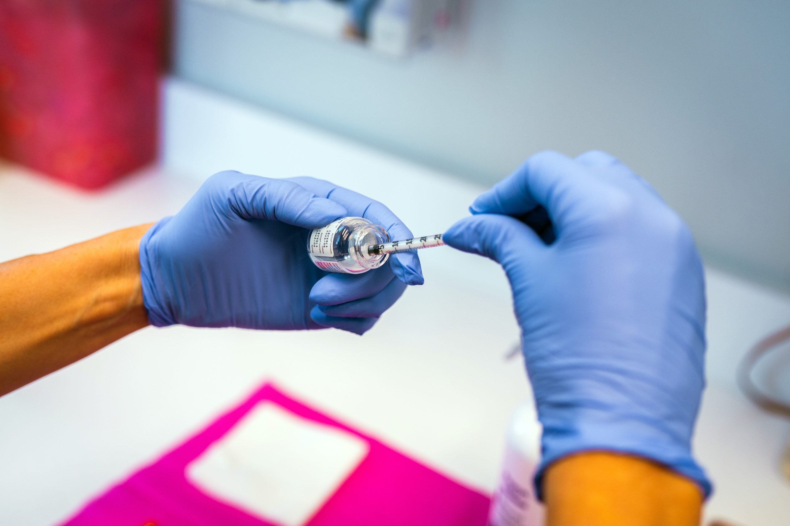 Professional with medical gloves prepares an injection needle