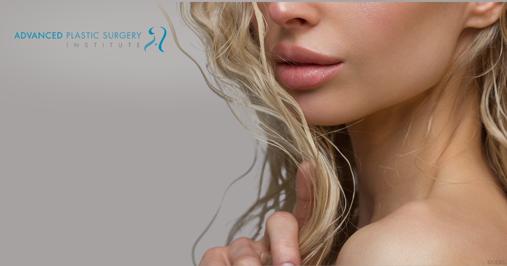 Close-up of a woman showing lip filler results (model) Advanced Plastic Surgery Institute Logo